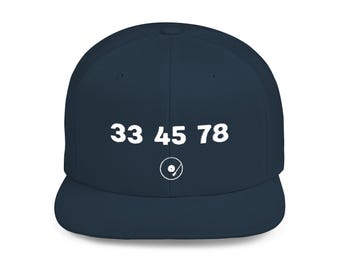 以下が含まれることがあります： ネイビーブルーのフラットブリム野球帽。前面には白で「33 45 78」の数字と、レコード盤の白いグラフィックが描かれています。音楽愛好家のためのスタイリッシュなアクセサリーです。