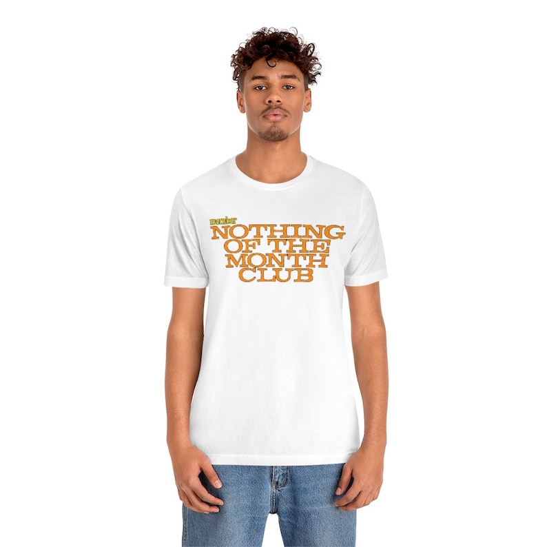 Peut inclure: T-shirt blanc avec le texte "The Best Nothing of the Month Club" en lettres orange et jaunes.