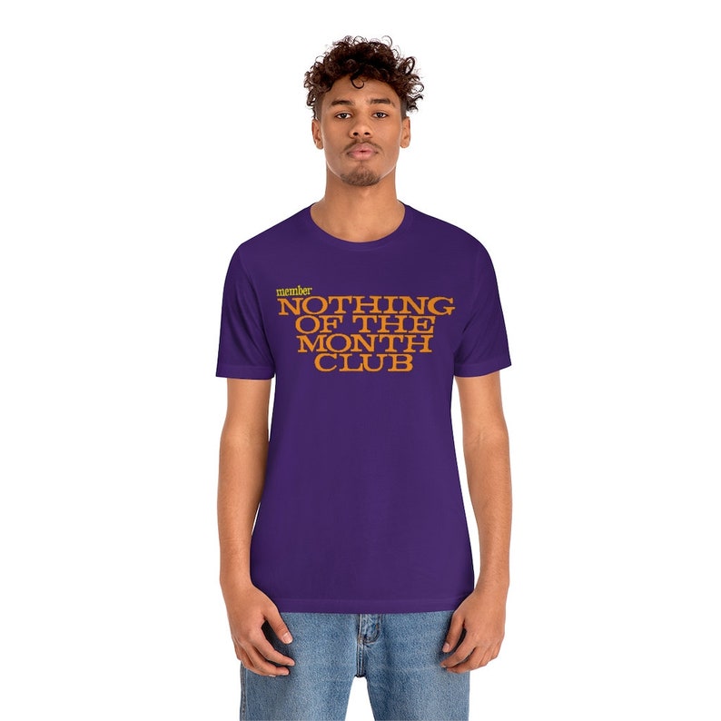 Peut inclure: T-shirt violet avec le texte "member NOTHING OF THE MONTH CLUB" en orange.