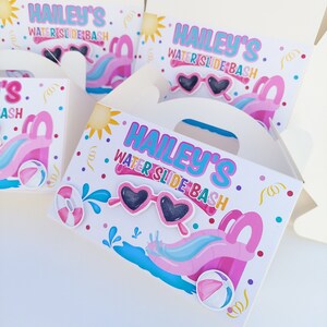 May include: A white favor box with a pink and blue water slide design. The box has a handle and says "Hailey's Water Slide Bash" on the front.