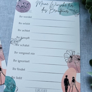May include: A rectangular wedding advice card featuring the German text Meine Wünsche für das Brautpaar, with prompts like Ich hoffe, Ihr werdet, and Ihr liebt. The design includes black line art of flowers, wedding rings, and a couple, with soft watercolour-style shapes in muted pink, green, and purple tones.