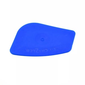 May include: Blue plastic squeegee with a rounded edge and a hole in the center. The squeegee has the text "TM  CH-117ER" printed on it.
