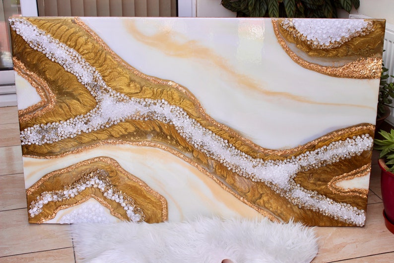 May include: Abstract art painting on canvas with white and gold flowing lines and white glitter accents.