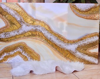 Puede incluir: Pintura abstracta de arte con colores blanco, dorado y beige. La pintura presenta un diseño fluido y orgánico con una superficie texturizada. La pintura está enmarcada y lista para colgar.