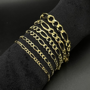 May include: A set of gold chain bracelets of varying widths and lengths. The chains are all made of a classic, flat, curb link design.