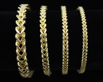 May include: Four gold chains of different lengths and widths, all featuring a classic Franco chain pattern.