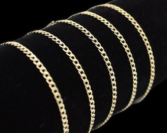 May include: A close-up of a gold chain necklace on a black velvet display stand. The chain is made of multiple strands of linked metal.