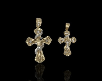 Op de afbeelding: Twee gouden kruis hangers met een diamant-achtig ontwerp. De grotere hanger heeft een figuur van Jezus Christus op het kruis.