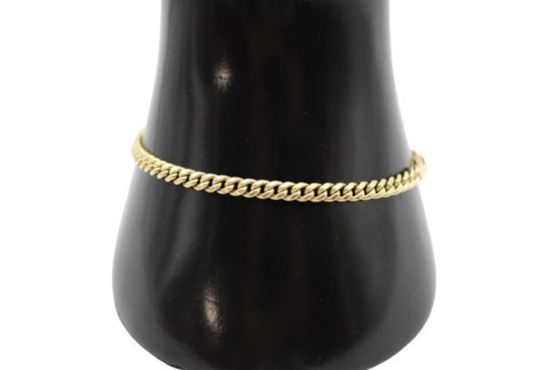 May include: A gold chain bracelet with a curb link design.