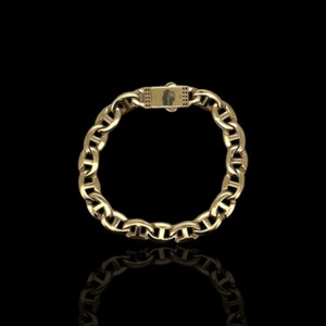 May include: A gold chain bracelet with a mariner link design. The bracelet has a clasp closure.
