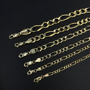 May include: A set of six gold chains with different lengths and widths. The chains are made of 10k gold and have a classic figaro design.