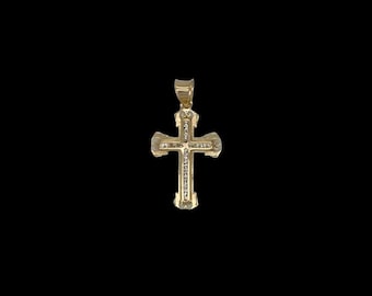 Puede incluir: Un colgante de cruz de oro con una fila de piedras transparentes en el centro.