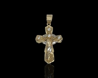 Op de afbeelding: Een gouden en witte tweekleurige kruis hanger met een gedetailleerd ontwerp en heldere stenen. Het kruis toont een figuur van Jezus Christus.