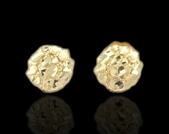 Könnte beinhalten: Ein Paar goldfarbene Ohrringe mit einem strukturierten, runden Design.