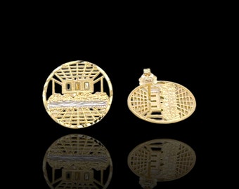May include: A pair of gold earrings with a detailed design of a building with a grid pattern. The earrings are round and have a post back.