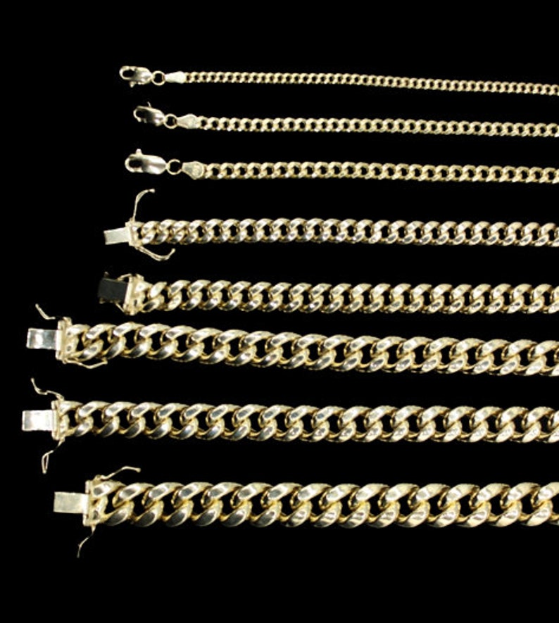 May include: Six gold chains of varying lengths and thicknesses, all with a curb link design. The chains are laid out horizontally on a black background.