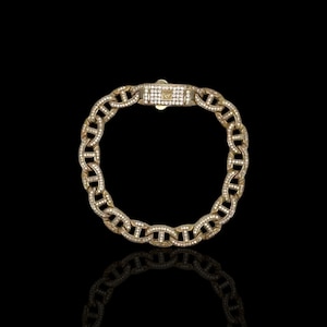 May include: A gold chain bracelet with a mariner link design. The bracelet is set with small, clear diamonds.