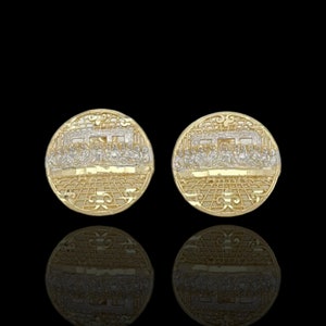 May include: A pair of gold earrings with a detailed design of the Last Supper. The earrings are round and have a two-tone finish.