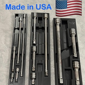 May include: Three sets of chrome socket extensions and sockets in black plastic trays. The trays are labeled with sizes 1/4, 3/8, and 1/2. The text "Made in USA" is visible, along with an American flag.