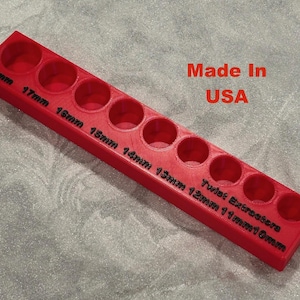 May include: Red plastic tool organizer with ten slots for twist extractor sizes 19mm, 17mm, 16mm, 15mm, 14mm, 13mm, 12mm, 11mm, 10mm, and 9mm. The organizer is labeled "Twist Extractors" and "Made in USA".