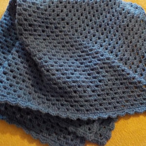 Peut inclure: Une couverture en crochet bleu avec un bord festonn&eacute;. La couverture est r&eacute;alis&eacute;e avec un point textur&eacute;.