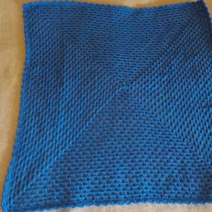 Peut inclure: Un plaid carr&eacute; bleu crochet&eacute; avec un motif en losange. Le plaid est r&eacute;alis&eacute; avec une maille simple au crochet et a un bord festonn&eacute;.