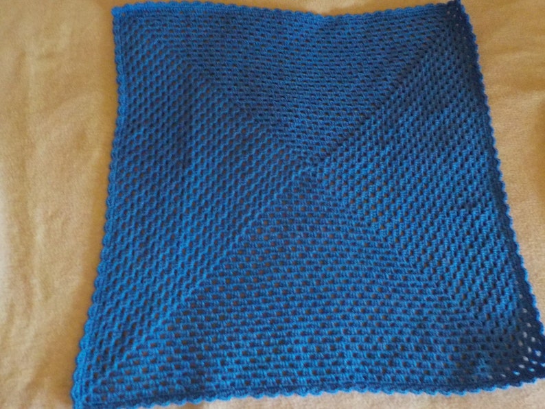 Peut inclure: Un plaid carr&eacute; bleu crochet&eacute; avec un motif en losange. Le plaid est r&eacute;alis&eacute; avec une maille simple au crochet et a un bord festonn&eacute;.