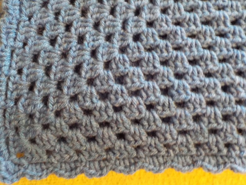 Peut inclure: Gros plan sur un tissu crochet&eacute; bleu avec un motif textur&eacute;.