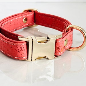 May include: A coral pink cork dog collar with a gold metal buckle and D-ring.