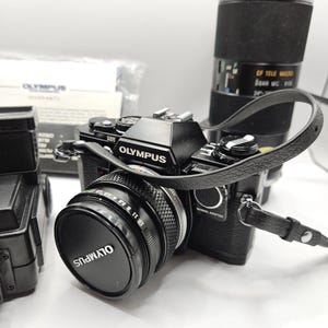 Olympus OM10 Black 35mm SLR w/ Zuiko 50mm f/1.8 & Tamron 70-210mm f/3.5 Lens