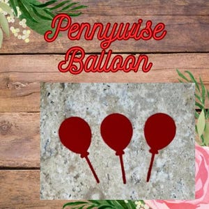 以下が含まれることがあります： 画像には、赤いスクリプトで「Pennywise Balloon」というテキストと、3つの赤い風船のシルエットが描かれています。 風船はテクスチャ加工された背景にあり、木製の板の背景と花のアクセントがあります。