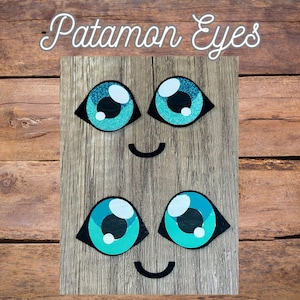May include: A wooden board with four cartoon eyes and two smiling mouths. The eyes are teal with white highlights and black eyelids. The text "Patamon Eyes" is written in a cursive font at the top of the board.