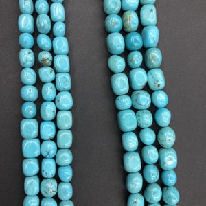May include: A strand of turquoise beads, featuring a light blue colour and a smooth, rounded shape. The beads are arranged in a linear pattern, creating a visually appealing and elegant design.