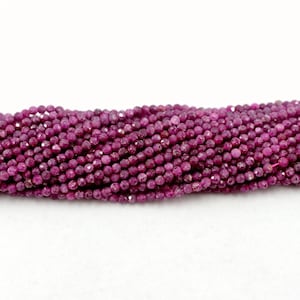 Puede incluir: Una hebra de cuentas de piedras preciosas de color rojo rubí. Las cuentas son redondas y tienen un acabado facetado.