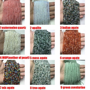 May include: Nine strands of beads, each a different color and type of gemstone. The beads are arranged in three rows of three, with each row labeled with a number and the name of the gemstone. The gemstones are: watermelon quartz, opalite, Indian agate, mother of pearl, moss agate, orange agate, mix agate, tree agate, and green aventurine.