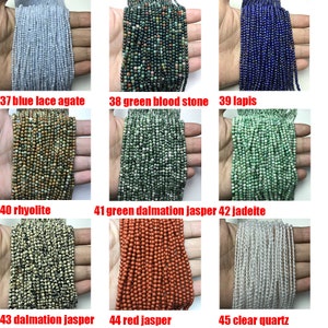 May include: Assortment of gemstone beads in various colors and patterns, including blue lace agate, green blood stone, lapis lazuli, rhyolite, green dalmatian jasper, jadeite, dalmatian jasper, red jasper, and clear quartz.