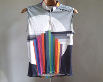 May include: A sleeveless cycling jersey with a white, gray, and black geometric design. The jersey has a full zipper and the brand name "GONSO" is printed on the right side of the chest.