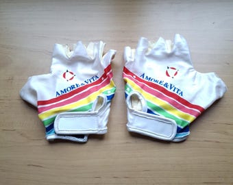 May include: A pair of white fingerless gloves with a rainbow stripe design and the text "Amore & Vita" in blue and red.