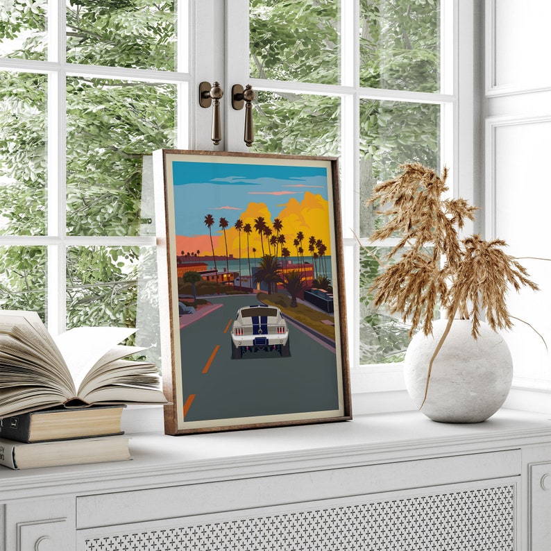 K&ouml;nnte beinhalten: Ein Vintage-Poster mit einem wei&szlig;en Ford Mustang, der eine von Palmen ges&auml;umte Stra&szlig;e in Richtung eines Strandes bei Sonnenuntergang entlangf&auml;hrt. Das Poster hat einen Retro-Vintage-Look.