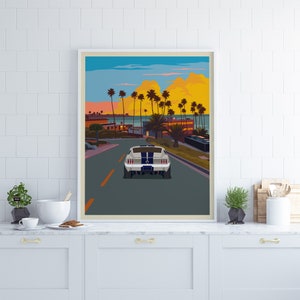 K&ouml;nnte beinhalten: Ein wei&szlig;er Ford Mustang f&auml;hrt auf einer Stra&szlig;e mit Palmen an beiden Seiten. Das Auto f&auml;hrt in Richtung des Ozeans in der Ferne. Der Himmel ist leuchtend blau mit rosa und orangefarbenen Wolken.