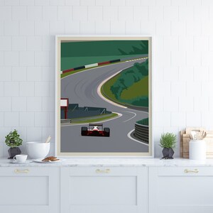K&ouml;nnte beinhalten: Ein rotes Rennwagen rast auf einer gr&uuml;nen und grauen Rennstrecke mit wei&szlig;en Linien. Das Auto befindet sich in der Mitte einer Kurve, im Hintergrund sind B&auml;ume und ein Zaun zu sehen.
