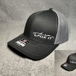 May include: Black and gray trucker hat with a white embroidered logo that says "FOX IT" with a stylized image of a fox.