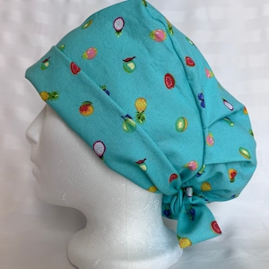 May include: A turquoise blue scrub hat with a colourful fruit print. The hat has a tie at the back.