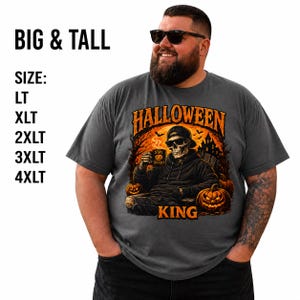 May include: A charcoal gray t-shirt featuring a graphic of a skeleton wearing a cap and sunglasses, holding a mug that says STAY SPOOKY. The text HALLOWEEN KING is printed in orange. The image includes text BIG & TALL and sizes LT, XLT, 2XLT, 3XLT, 4XLT.
