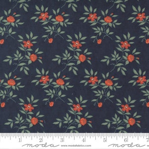 May include: A navy blue fabric with a repeating pattern of small red flowers and green leaves. The fabric has a white ruler with the word "moda" printed on it.