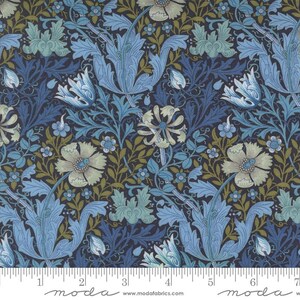May include: A fabric with a repeating floral pattern in shades of blue, green, and cream on a dark navy background. The design features stylized flowers and leaves, with a ruler along the bottom edge.