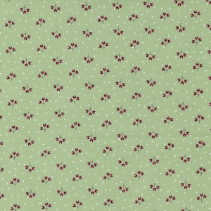 May include: A green fabric with a repeating pattern of small white dots and red berry clusters.