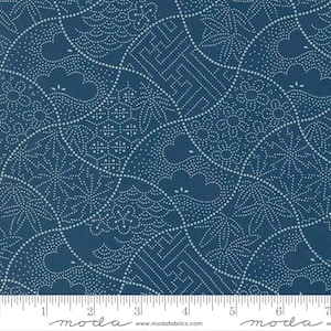 May include: A blue fabric with a white pattern of dots and lines. The fabric has a repeating pattern of geometric shapes and swirls. The fabric is measured with a ruler in inches.