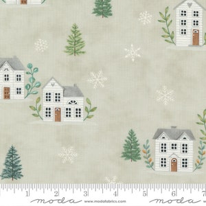 May include: A green and white fabric with a repeating pattern of white houses, green trees, and snowflakes on a light green background. The fabric has a ruler printed at the bottom with the words "moda" and "www.modafabrics.com".