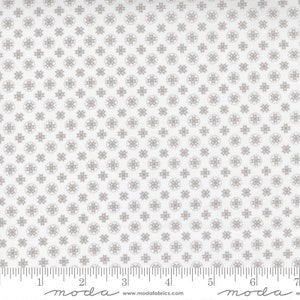 May include: White fabric with a repeating pattern of small gray circles and stars. The fabric is measured with a ruler in inches.